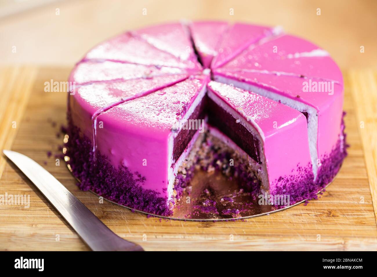 Torta di compleanno rosa e viola senza un pezzo. Dessert, vacanze e delizioso concetto. Foto Stock