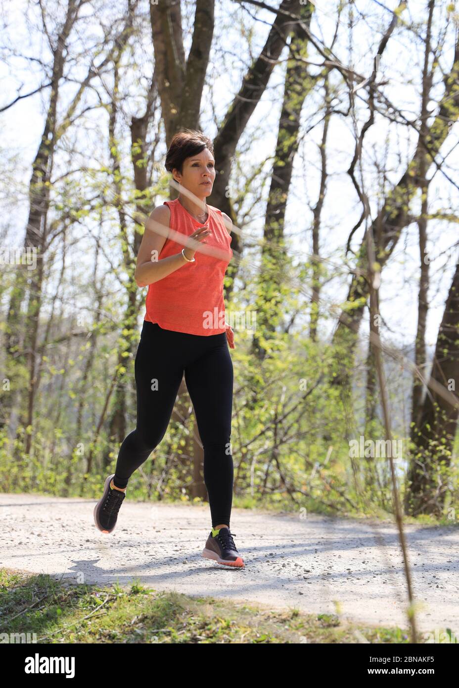 Donna, 40-45 anni, jogging in una zona forestale a Monaco, Baviera, Germania. Foto Stock