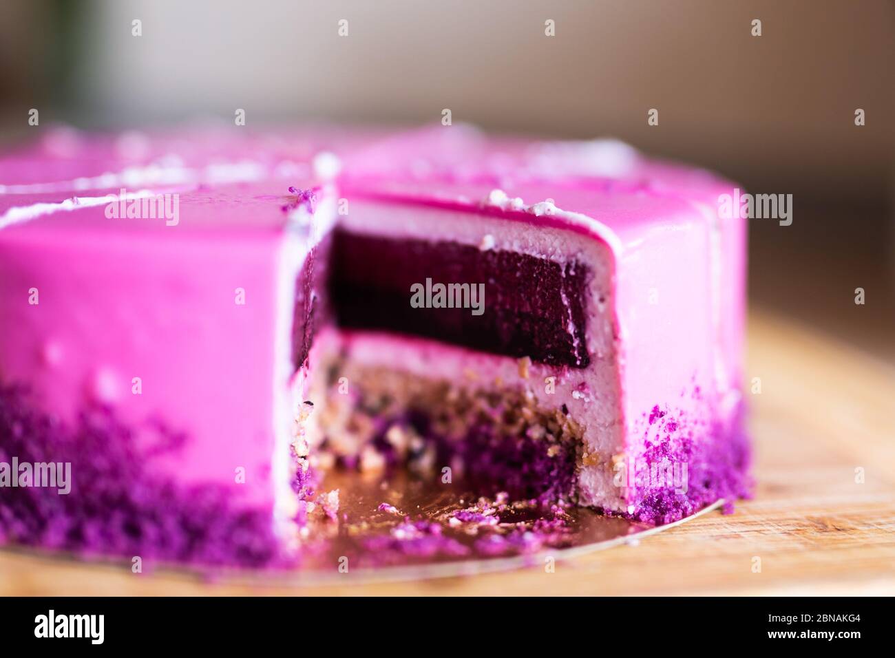 Torta di compleanno rosa e viola senza un pezzo. Dessert, vacanze e delizioso concetto. Foto Stock