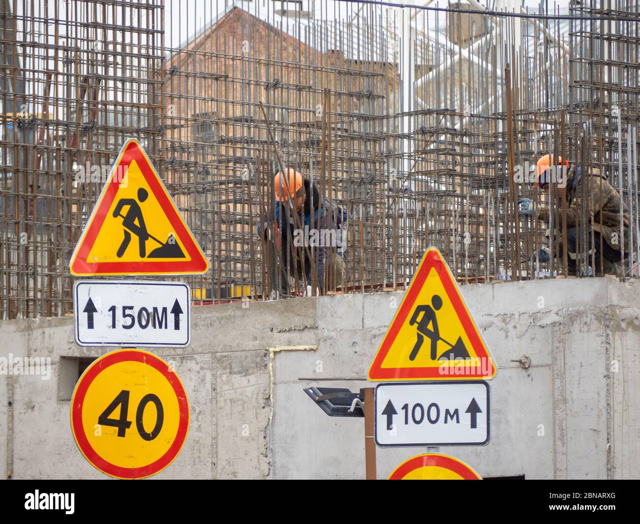 Lavoratori edili che collaborano all'installazione di impianti in un cantiere. Foto Stock