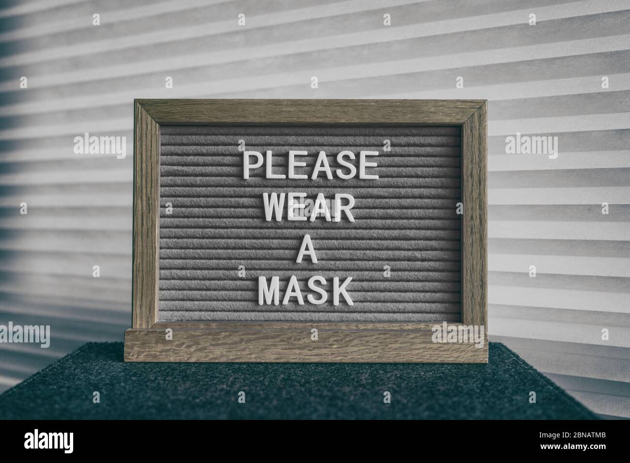 COVID-19 cartello preventivo di avviso sanitario con testo, SI PREGA DI INDOSSARE UNA MASCHERA all'ingresso del negozio per la prevenzione del coronavirus. Misura obbligatoria per le aziende per la protezione del viso indossare. Foto Stock