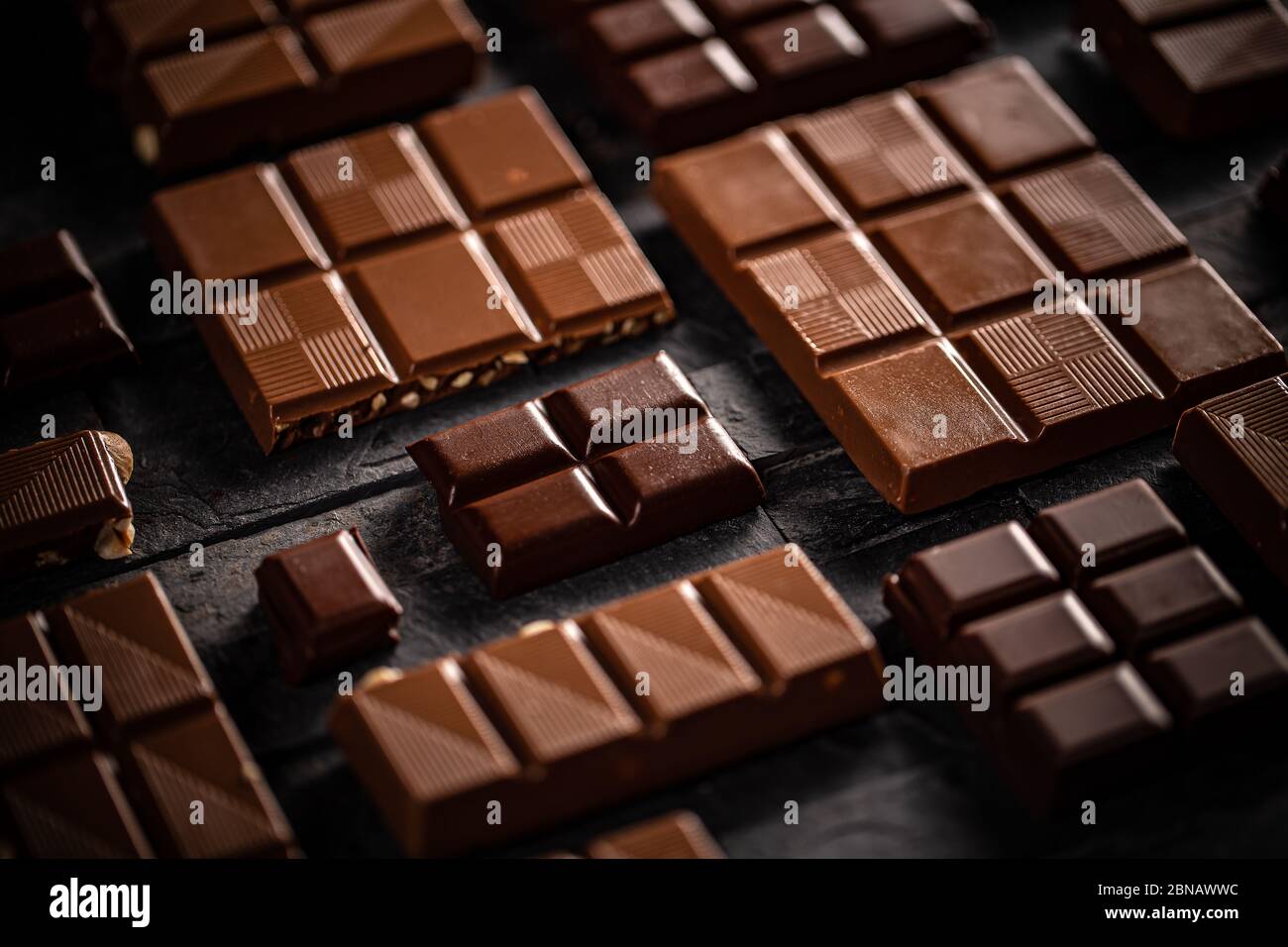 Barrette di cioccolato al latte e alle nocciole su sfondo nero Foto Stock