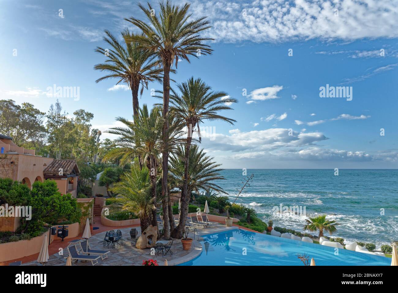 Vista sulla piscina e sul mare Mediterraneo in una giornata di sole - Vacanze, destinazione di viaggio - Arbatax, Sardegna, Italia - 18 maggio 2019 Foto Stock