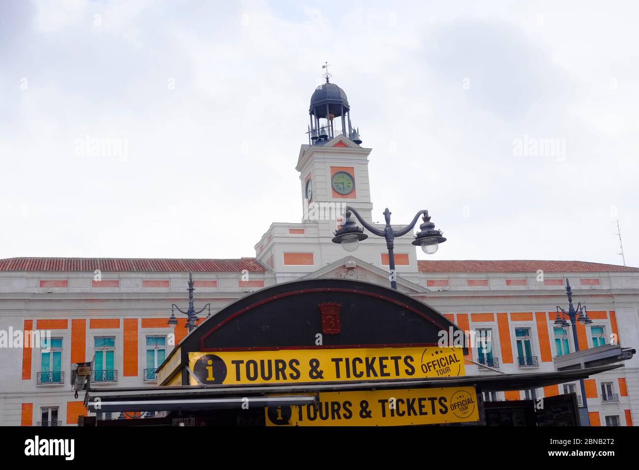 Parte superiore del chiosco di edicola a Puerta del Sol, Madrid, con la Real Casa de Correos sullo sfondo. Foto Stock