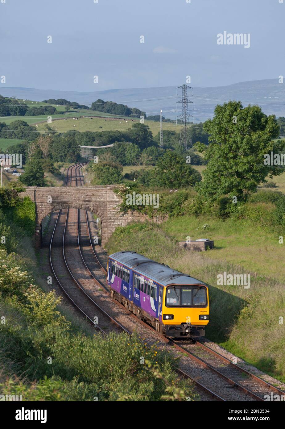 Treno a cremagliera della classe 144 della ferrovia nord-occidentale 144005 sulla panoramica linea ferroviaria nord-occidentale che passa per la campagna di Keerholme Foto Stock