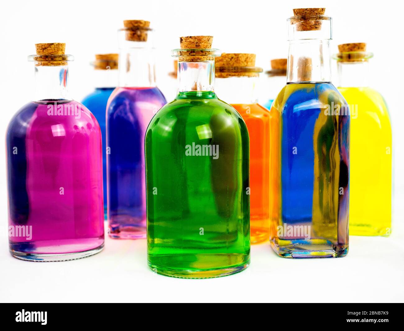 Bottiglie colorate su sfondo bianco Foto Stock