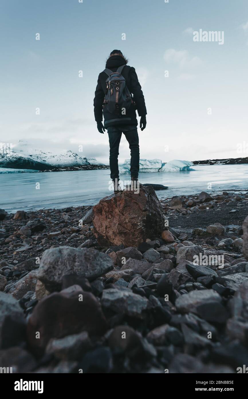 Escursioni su un ghiacciaio in Islanda, viste mozzafiato, il viaggiatore si erge sulla pietra Foto Stock