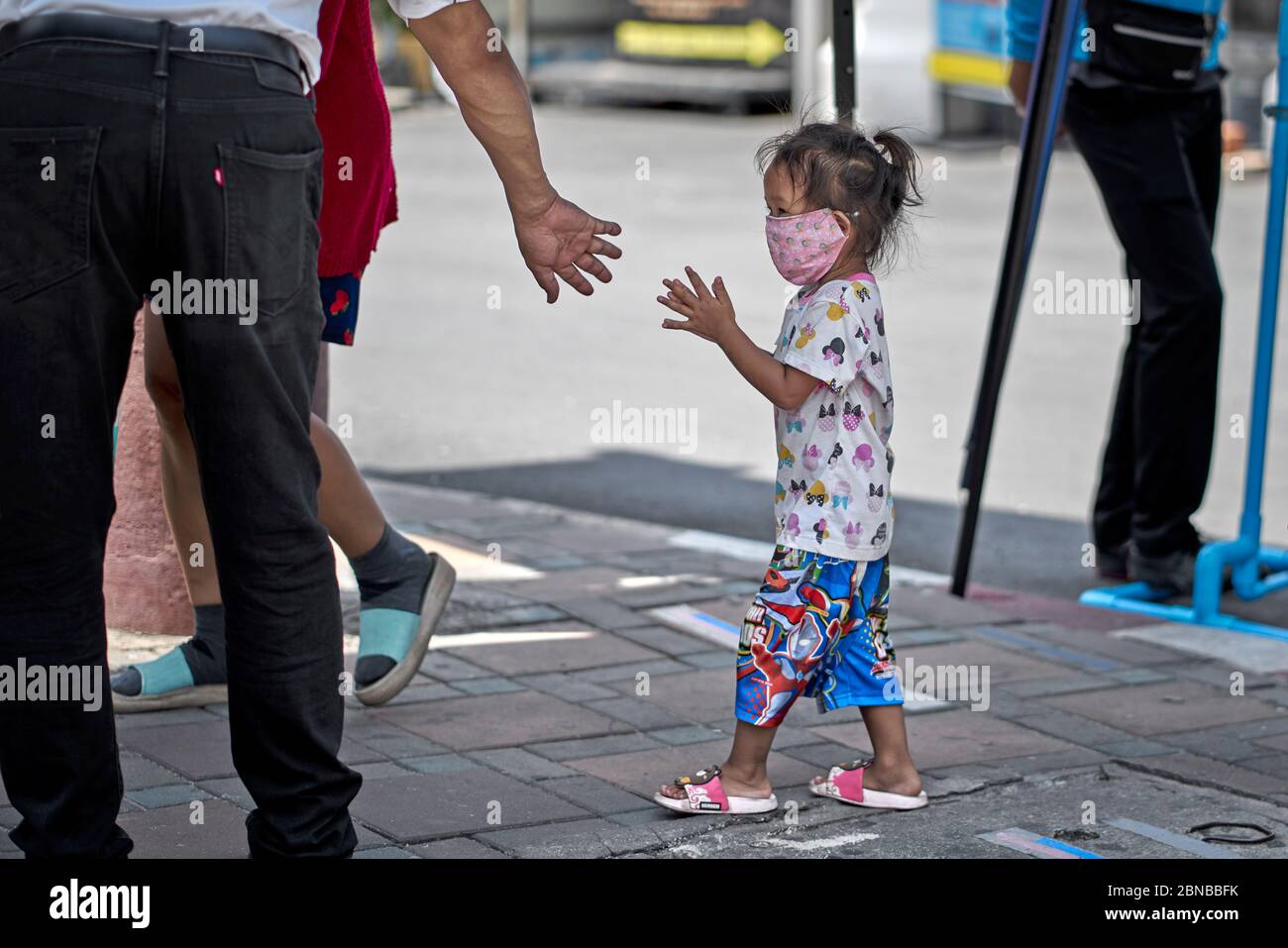 Covid-19. Bambini che puliscono le mani con l'igienizzatore e che procedono ad un handout libero del cibo fornito dalle aziende locali a Pattaya Thailandia. Foto Stock