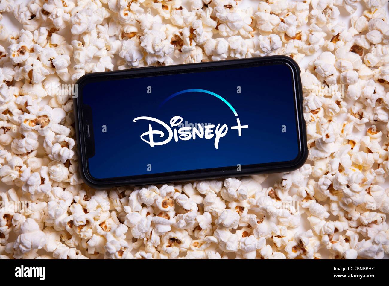 LONDRA, UK - MAGGIO 14 2020: Logo Disney Plus su uno smartphone con popcorn Foto Stock