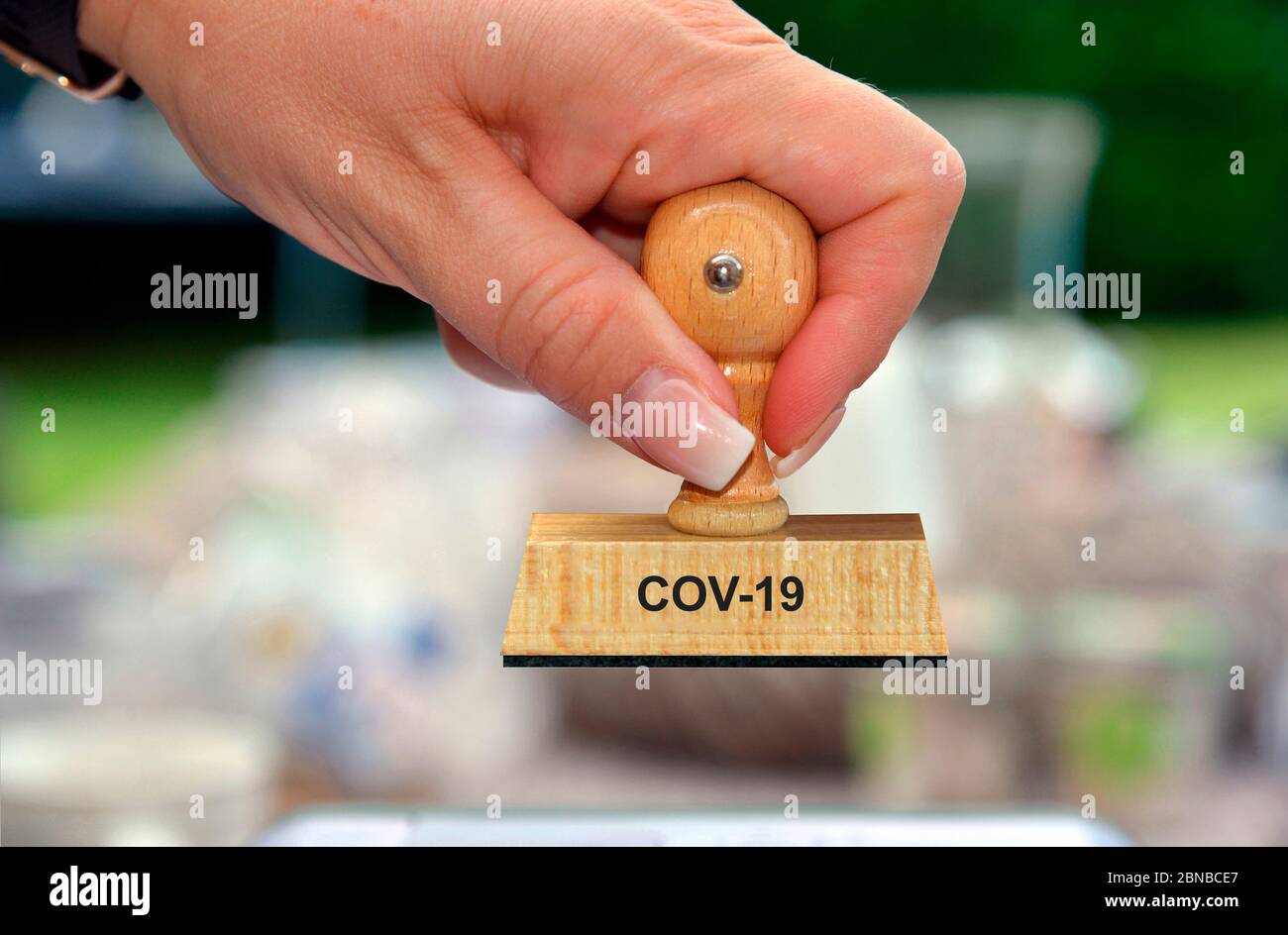 Timbro in mano di una donna scritta COV-19, Germania Foto Stock