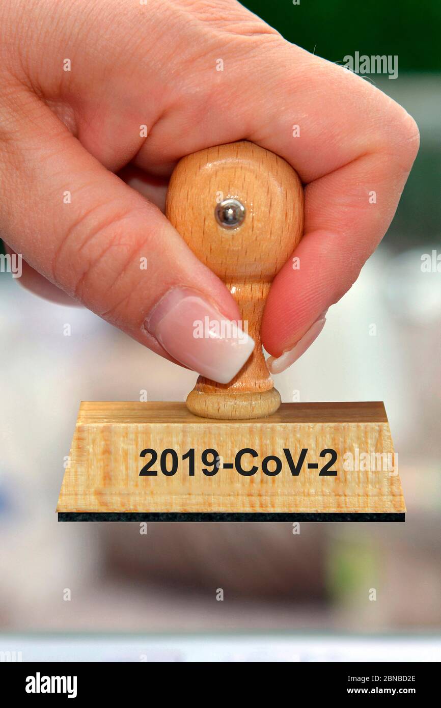 Timbro in mano di una donna scritta 2019-cov-2, Germania Foto Stock