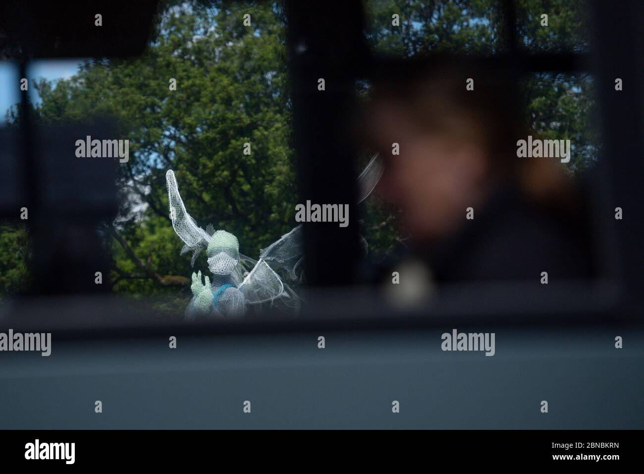 Un autobus passa lo scultore Luke Perry's aled medico lavoratore, che è stato installato in un parco vicino Birmingham rendendo omaggio al NHS e operatori di cura durante la pandemia coronavirus. L'angelo alto quattro metri, realizzato in metallo e materiali già sdraiato nella sua fabbrica, nel Lightwoods Park di Bearwood, si trova su un percorso principale per tre ospedali locali. Foto Stock