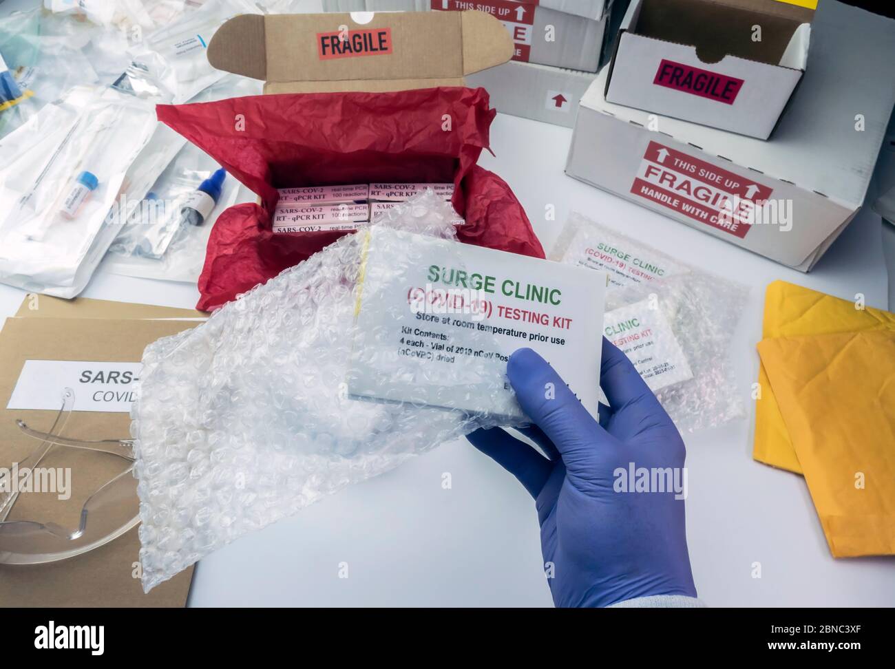 Scatola di disimballaggio infermiere con kit PCR Covid-19 in magazzino ospedaliero, immagine concettuale Foto Stock