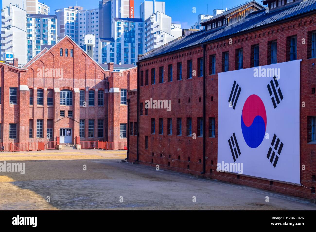 Una grande bandiera coreana appesa all'esterno di un edificio presso la Sala di Storia della prigione di Seodaemun, museo ed ex prigione di Seodaemun-GU, Seoul. Foto Stock