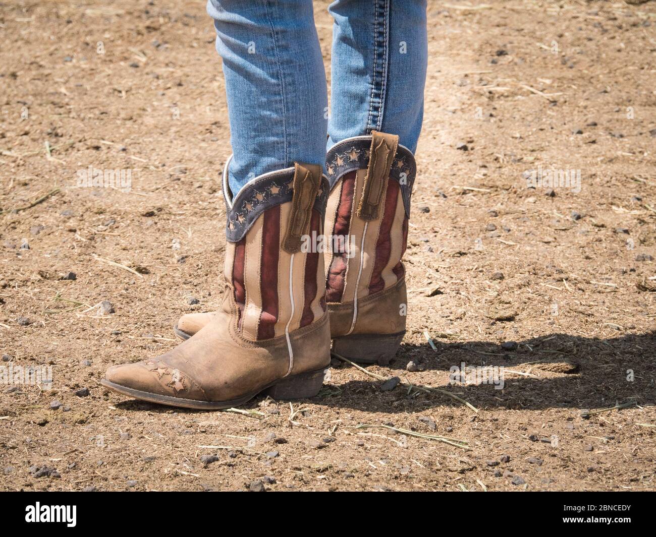 Stivali da cowboy con bandiera americana e jeans blu nascosti all'interno. Foto Stock