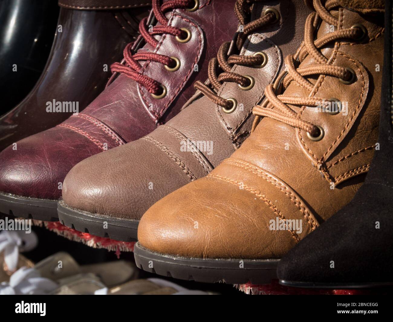 La parte anteriore di tre diversi stivali in pelle colorati si trova su una mensola in un negozio di scarpe a El Paso, Texas. Foto Stock