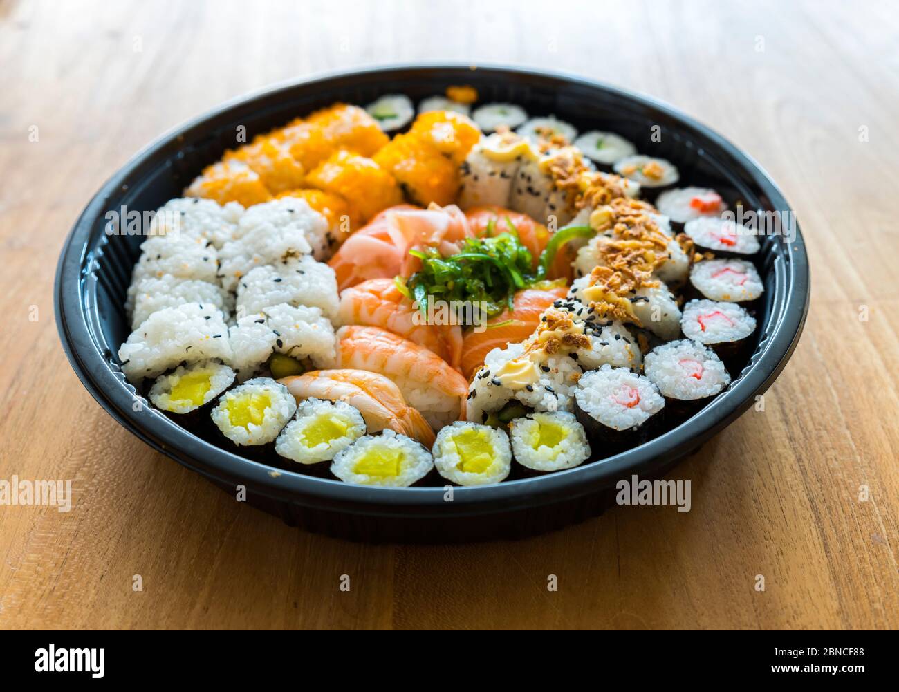 Un piatto fresco di sushi con riso e pesce su sfondo di legno Foto Stock