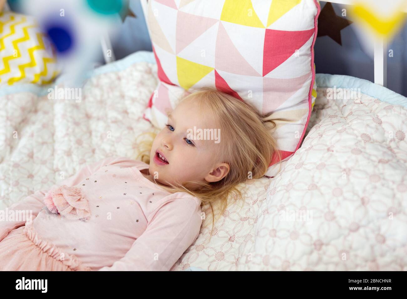Felice 3 anni adorabile ragazza sdraiata a letto Foto Stock
