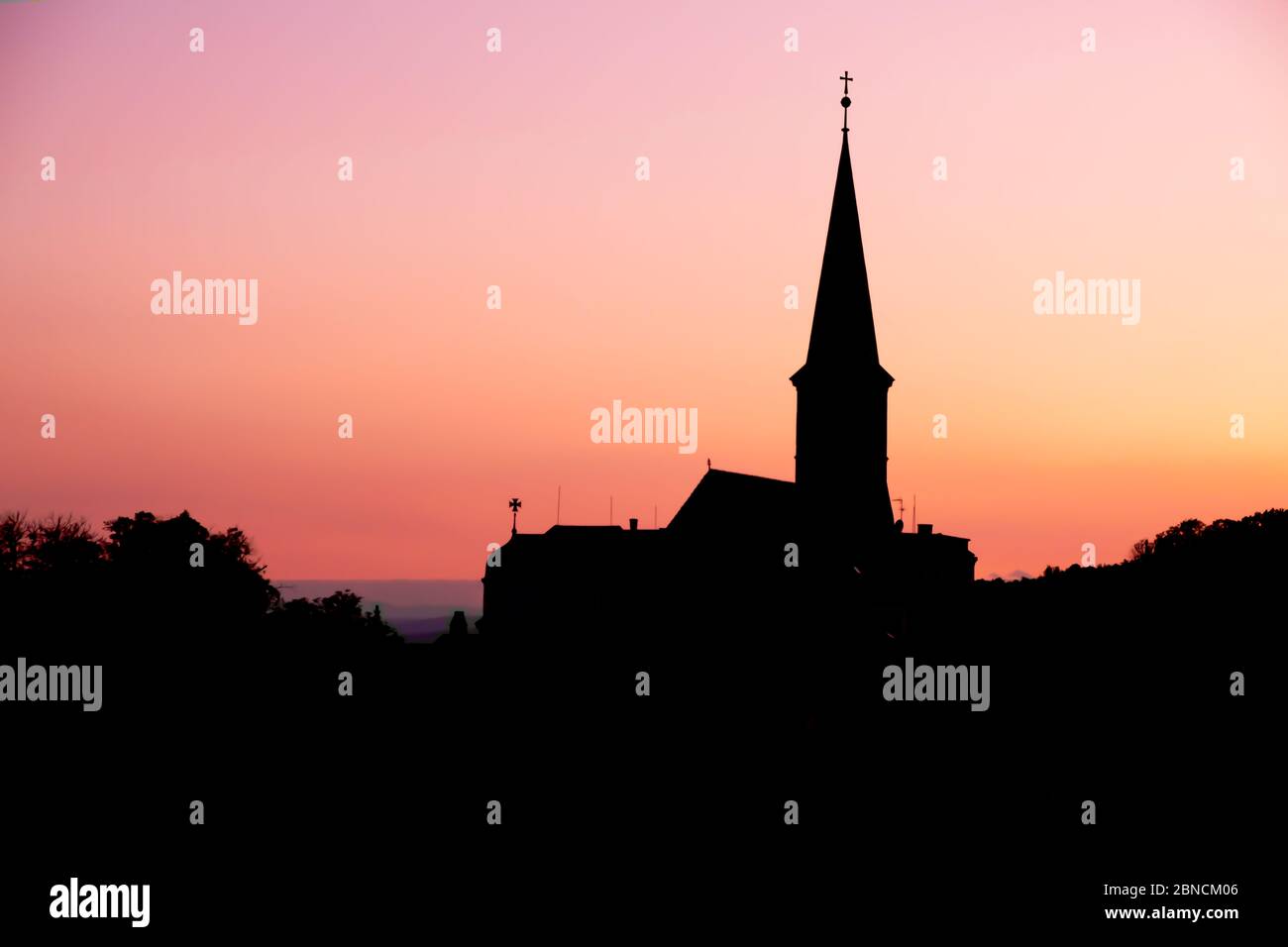 Silhouette vista della chiesa parrocchiale ortodossa in serata a Gumpoldskirchen, un luogo famoso per il suo vino e Heurigers come una grande collina vigneti. Foto Stock