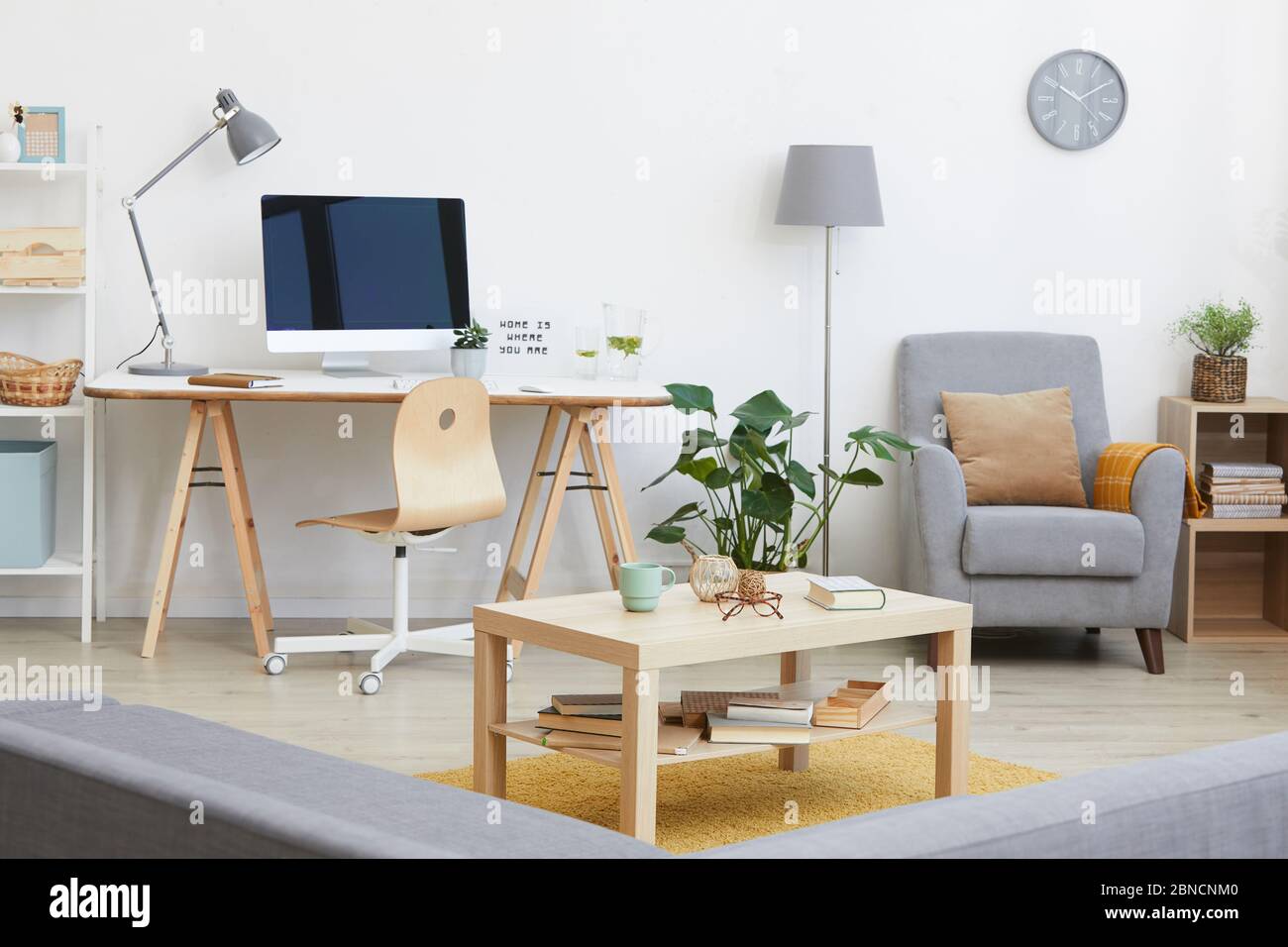 Immagine del soggiorno con posto di lavoro con monitor per computer su di esso e altri mobili moderni in casa Foto Stock