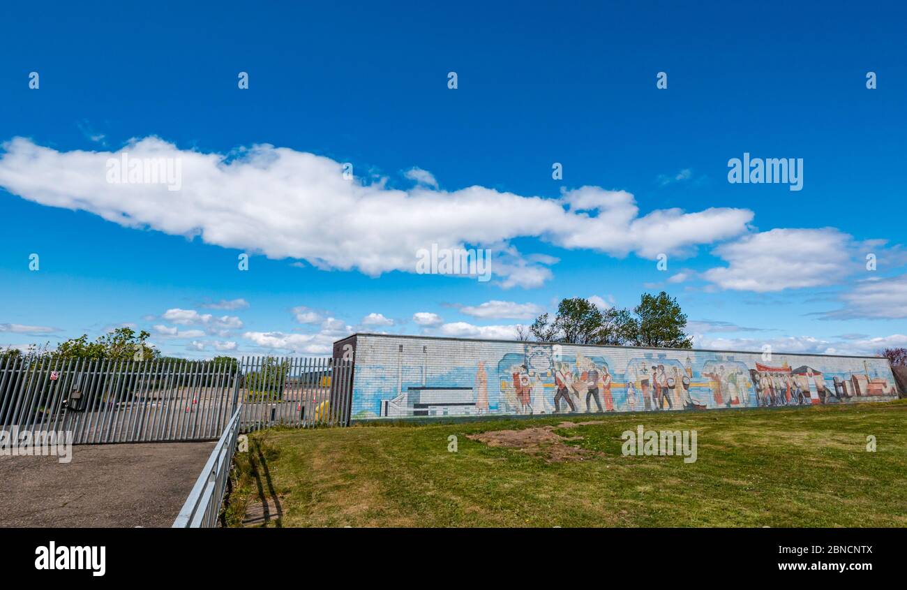 Cockenzie, East Lothian, Scozia, Regno Unito. 14 maggio 2020. Stazione di test Covid-19: L'ex stazione di alimentazione di Cockenzie, acquistata dal Consiglio di East Lothian da Scottish Power, è in fase di preparazione per essere utilizzata come centro di test drive-through COVID-19. Sarà gestito dai militari (51 ° Brigata di Fanteria) per i lavoratori chiave o un membro della loro famiglia con sintomi. Il sistema opererà come una struttura autonoma e drive-through con persone che rimangono nei veicoli durante i test come parte della campagna Test, Track, Isolate del governo scozzese. Un murale raffigurante il patrimonio industriale locale Foto Stock