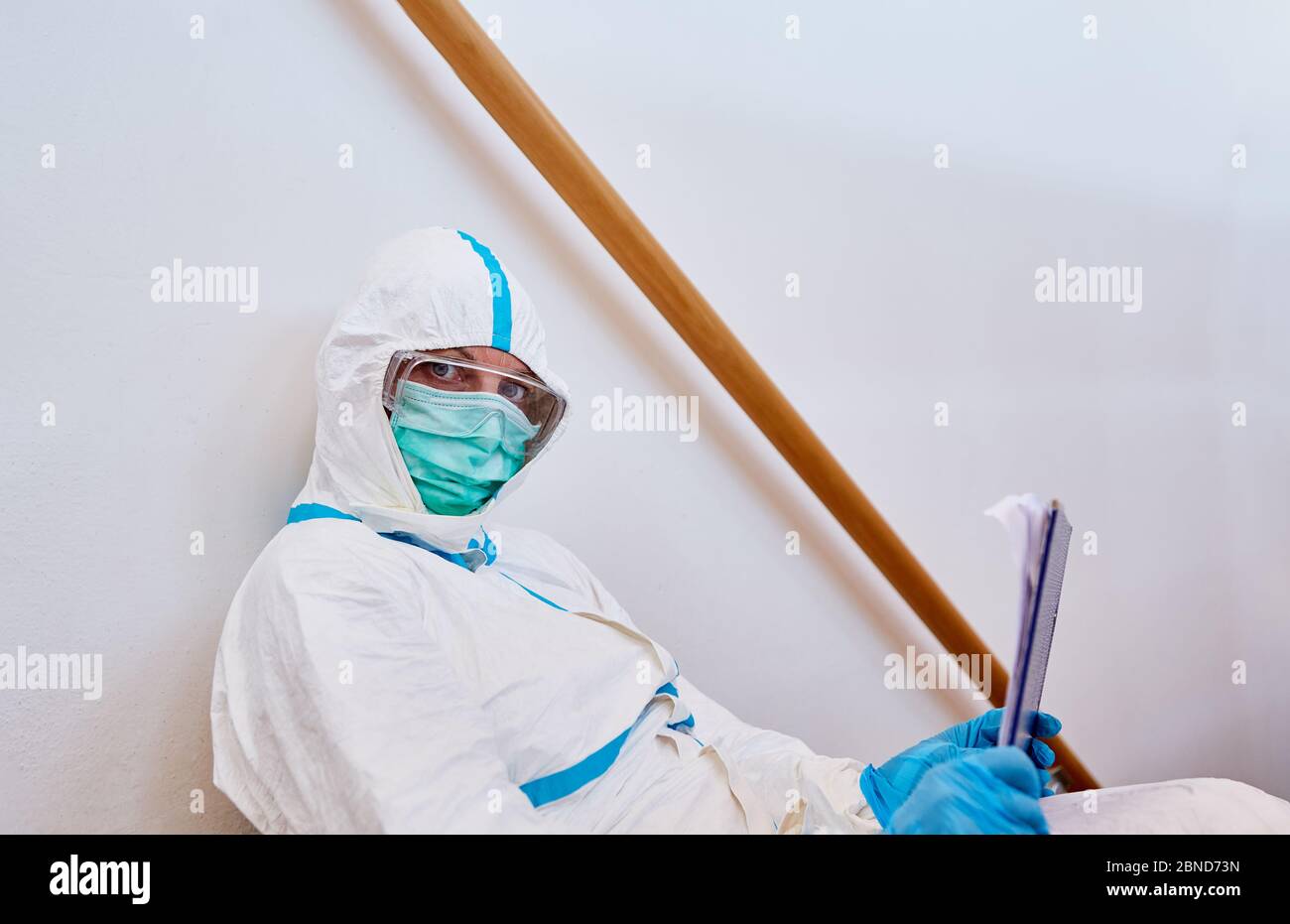 Scout di contenimento in indumenti protettivi con checklist per il monitoraggio del contatto in pandemia di coronavirus Foto Stock