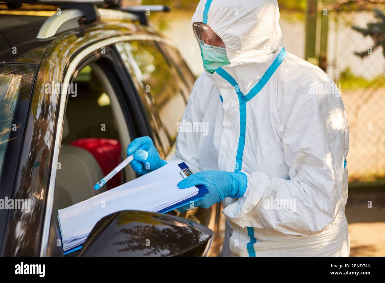 Test del coronavirus con tampone alla gola nella stazione di test drive-in mediante scout di contenimento del reparto sanitario Foto Stock