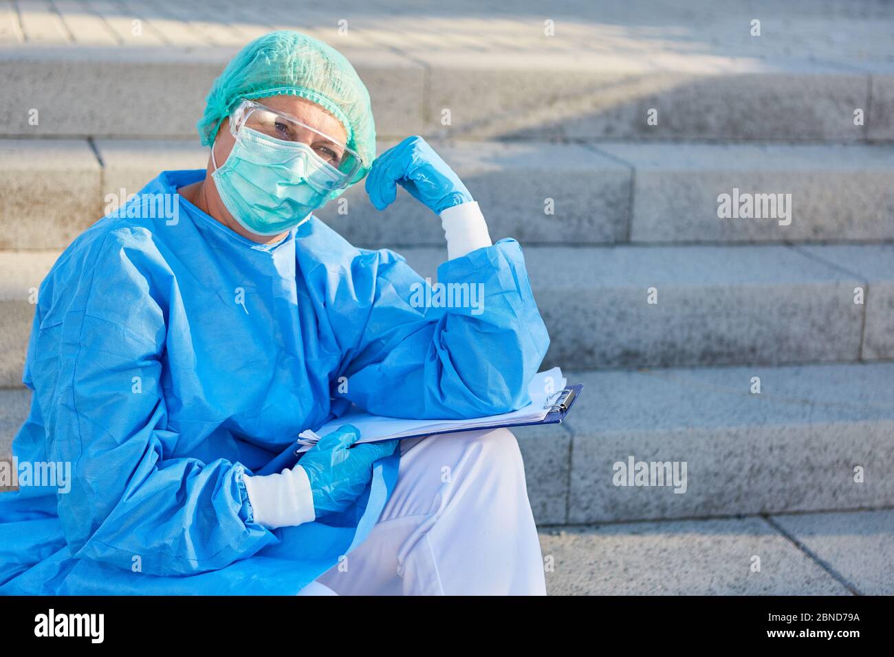 Il personale della clinica come scout di contenimento attende con la lista di monitoraggio dei contatti per i visitatori di pandemia di coronavirus Foto Stock