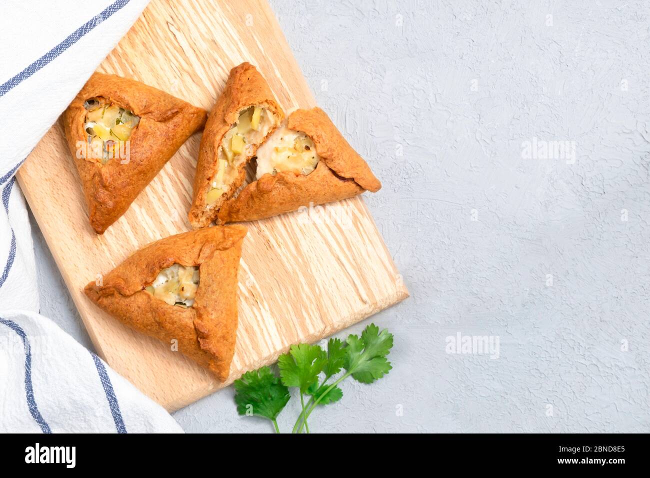 Tatar tradizionale pasticceria triangolare con patate, cipolla, carne su fondo neutro. Immagine con spazio di copia, vista dall'alto Foto Stock
