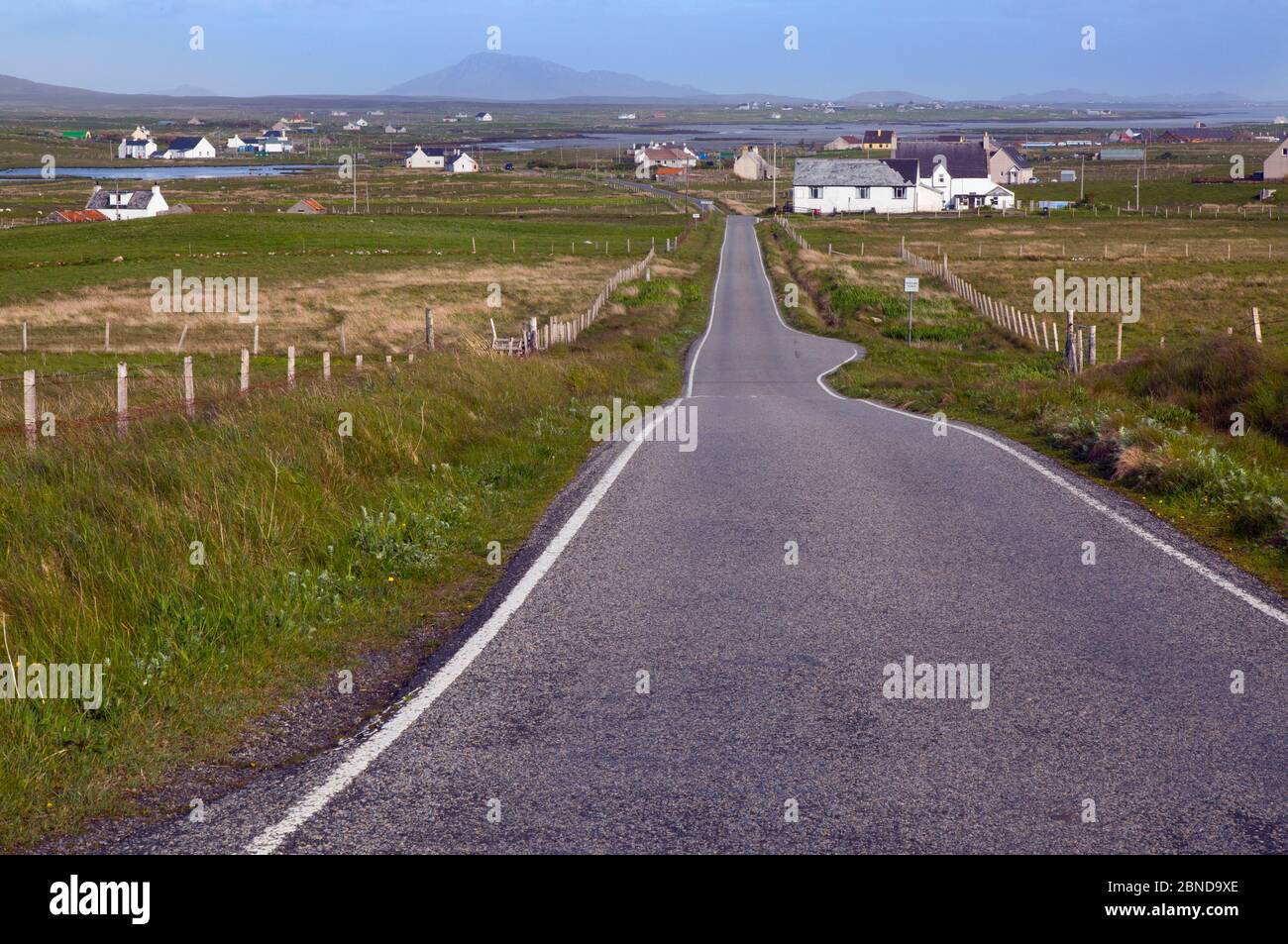 Unica via strada e crofters case, Baile Mor, North Uist, Ebridi Esterne, Scozia, Giugno. Foto Stock