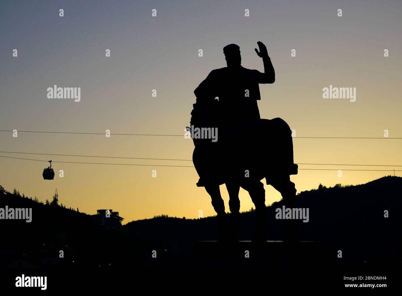 Tbilisi: Monumento del re Vakhtang Gorgasali, al tramonto, con funivia sullo sfondo. Georgia Foto Stock