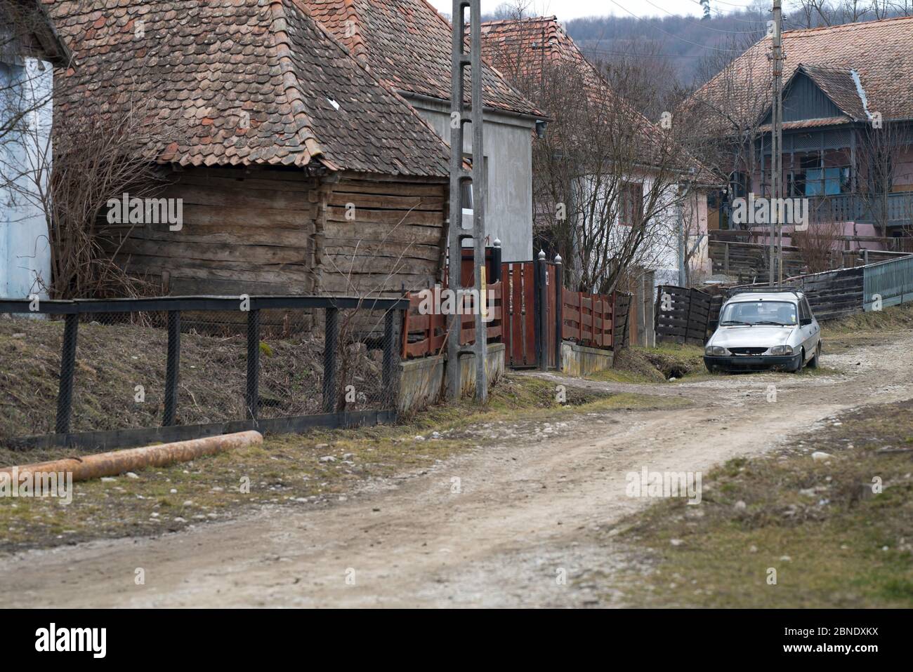Tipica vista sulla strada del villaggio in Romania. Strada sterrata, case in rovina. Foto Stock