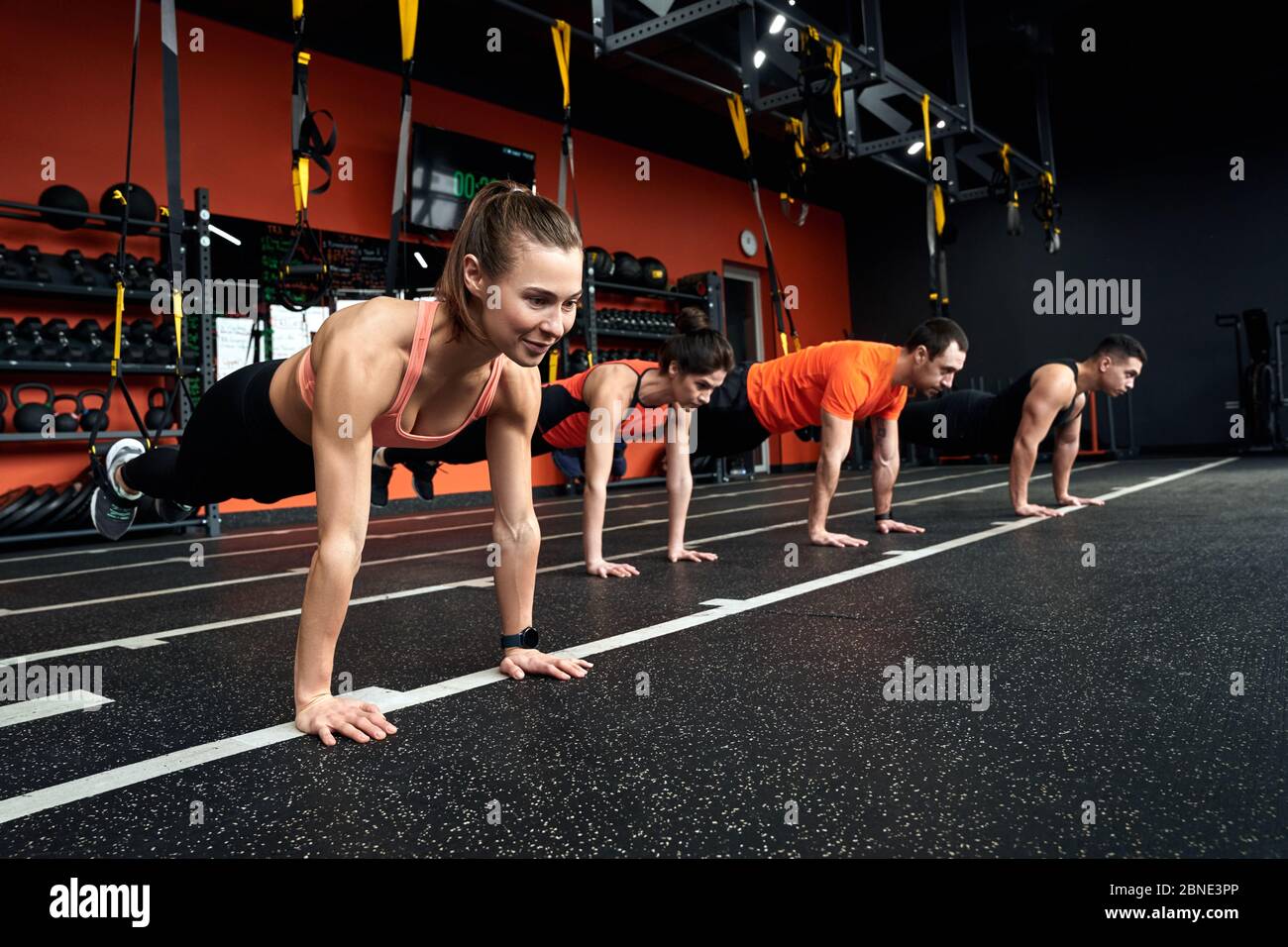 Stile di vita sportivo. Giovani che fanno esercizi TRX push-up in palestra  sorridendo gioioso Foto stock - Alamy
