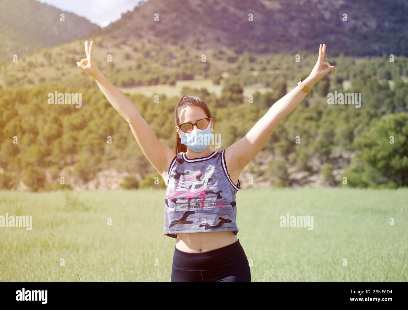 De-escalation del coronavirus, ritorno alla normalità dal COVID 19. Giovane donna in maschera medica protettiva gode di libertà dopo la quarantena è finita. Rilasciare fe Foto Stock