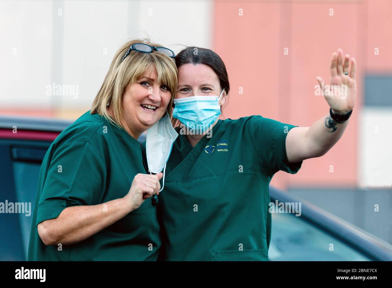 Newport, Galles, Regno Unito. 14 maggio 2020. Gli operatori sanitari che indossano maschere chirurgiche danno un'onda durante il clap per gli operatori sanitari e i lavoratori di prima linea NHS al Royal Gwent Hospital di Newport, Galles, Regno Unito. Credit: Tracey Paddison/Alamy Live News Foto Stock
