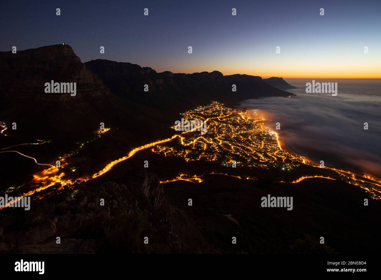 Sea Mist sopra Camps Bay, Città del Capo, visto di notte da Lions Head, Sud Africa Foto Stock