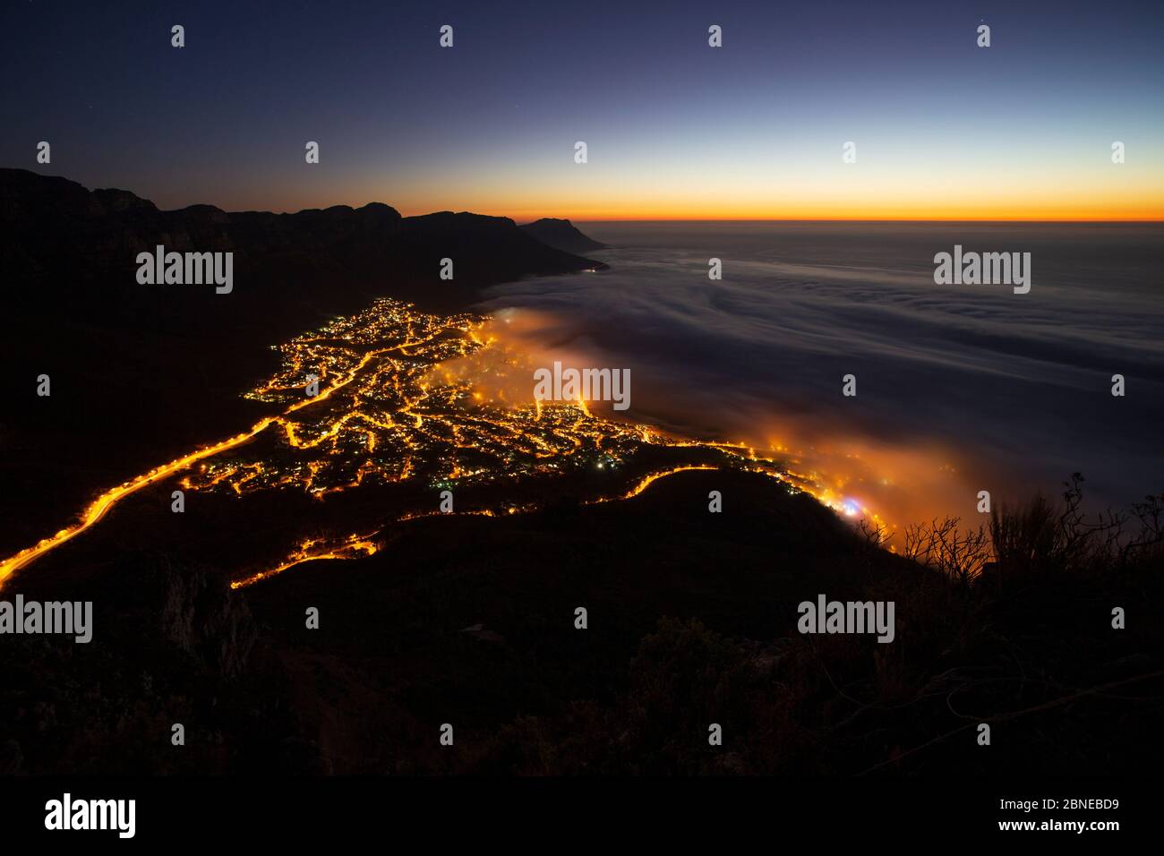 Sea Mist sopra Camps Bay, Città del Capo, visto di notte da Lions Head, Sud Africa Foto Stock