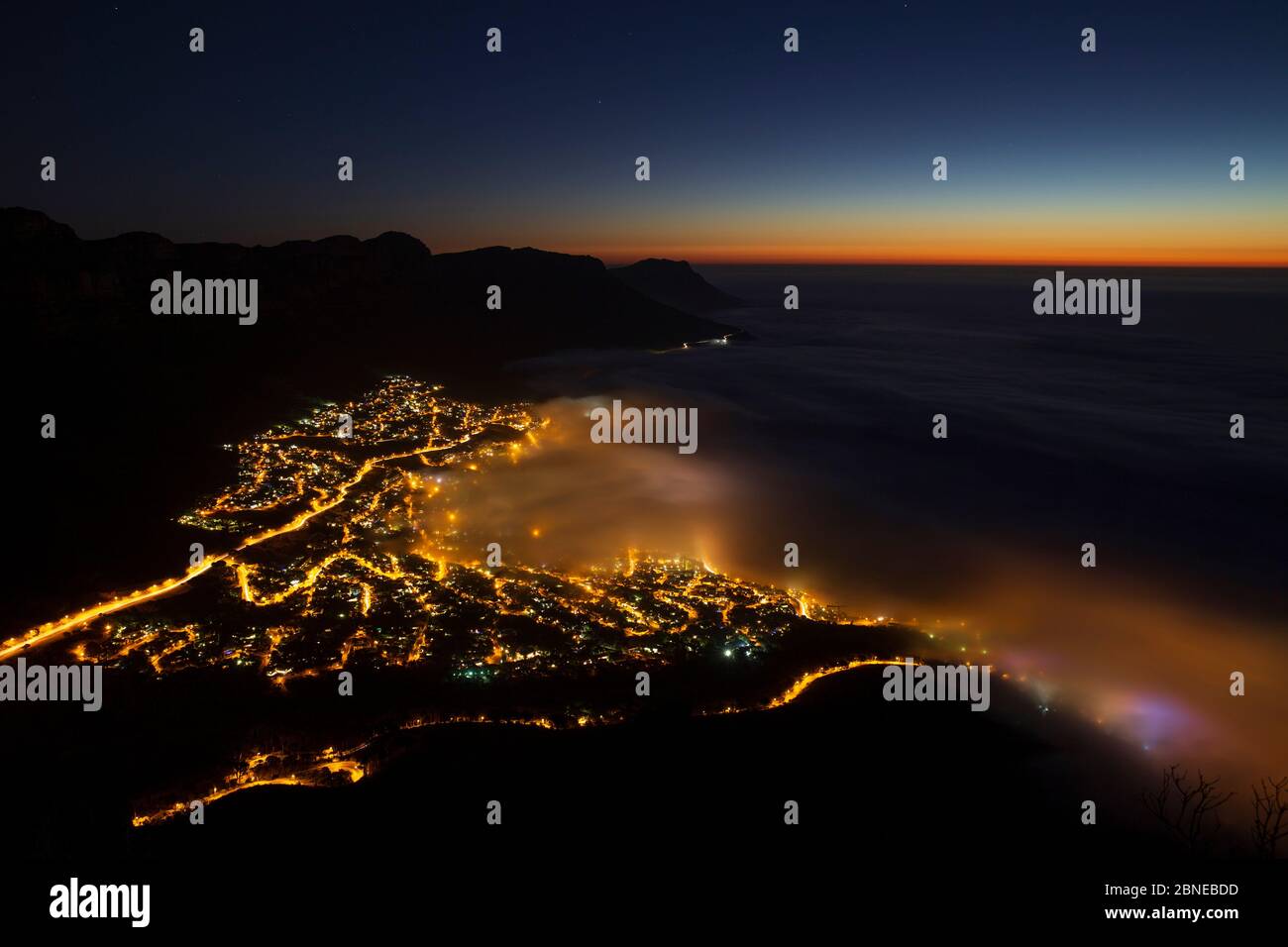 Sea Mist sopra Camps Bay, Città del Capo, visto di notte da Lions Head, Sud Africa Foto Stock