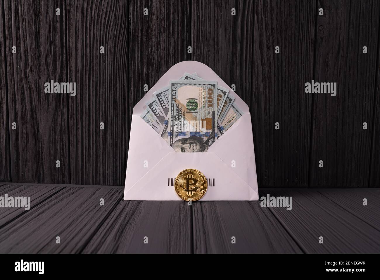 Moneta di Bitcoin d'oro in Crypto vicino alla busta con banconote in dollari. Foto Stock