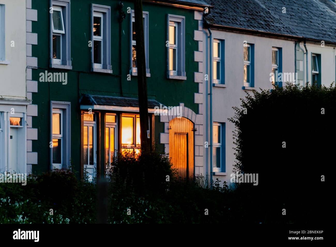 Courtmacsherry, West Cork, Irlanda. 14 maggio 2020. Il sole tramonta in modo spettacolare come riflesso in una finestra di una casa a Courtmacsherry dopo una giornata di sole. Credit: Notizie dal vivo di AG/Alamy Foto Stock