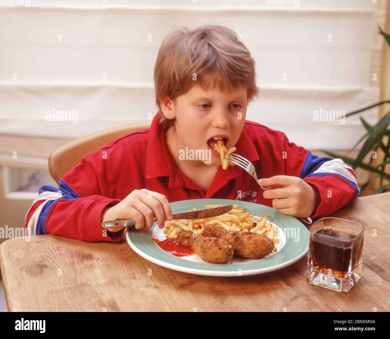 Giovane ragazza che mangia pollo fritto e patatine, Winkfield, Berkshire, Inghilterra, Regno Unito Foto Stock