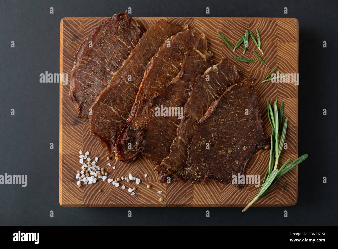 Primo piano di un pezzo di carne su un asse di legno con spezie. Menu del ristorante, una serie di foto di diversi piatti Foto Stock