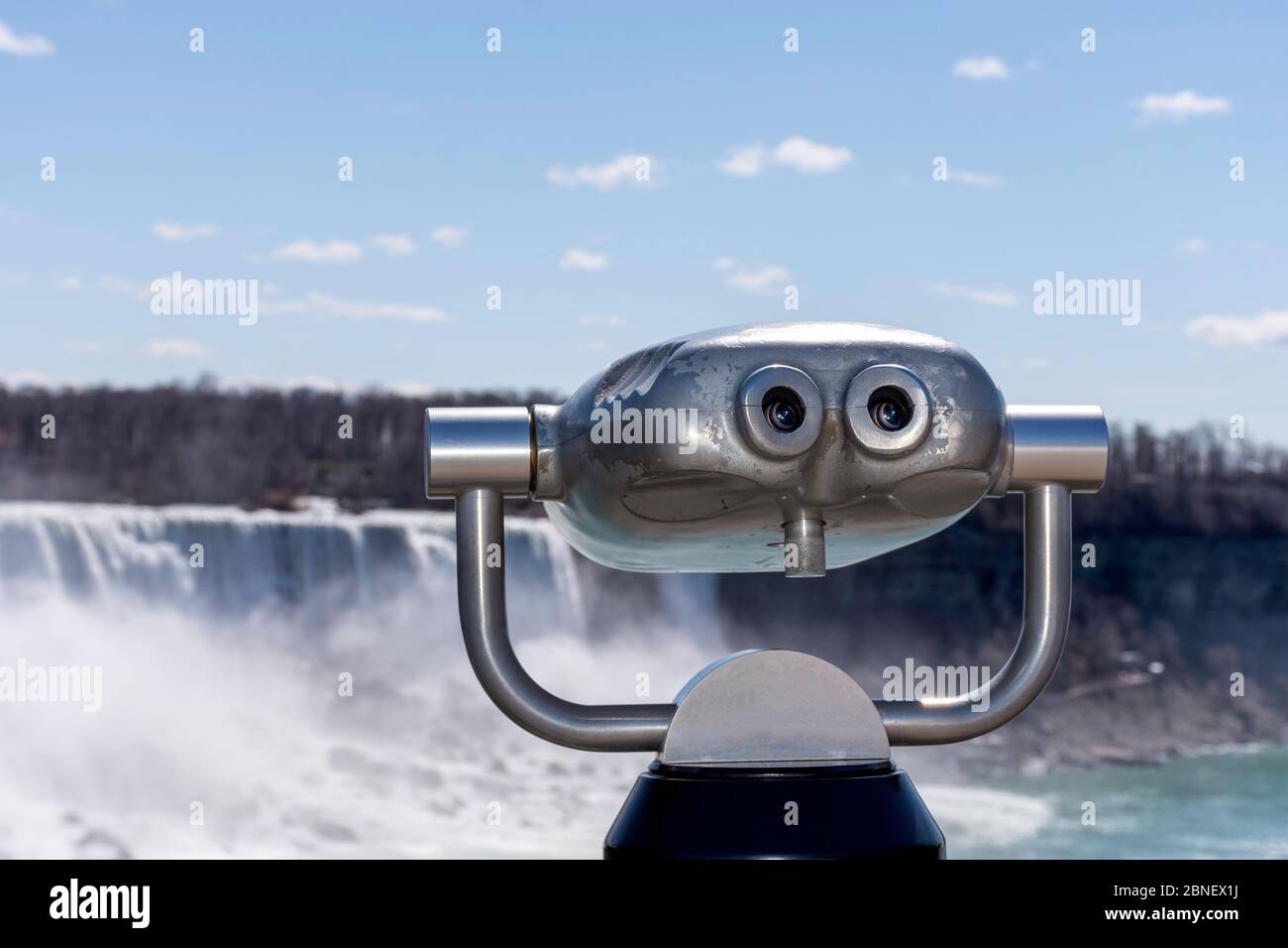 Binocolo a gettoni per il turismo con cascate del Niagara sullo sfondo. Concetto di riapertura del confine USA-Canada. Foto Stock