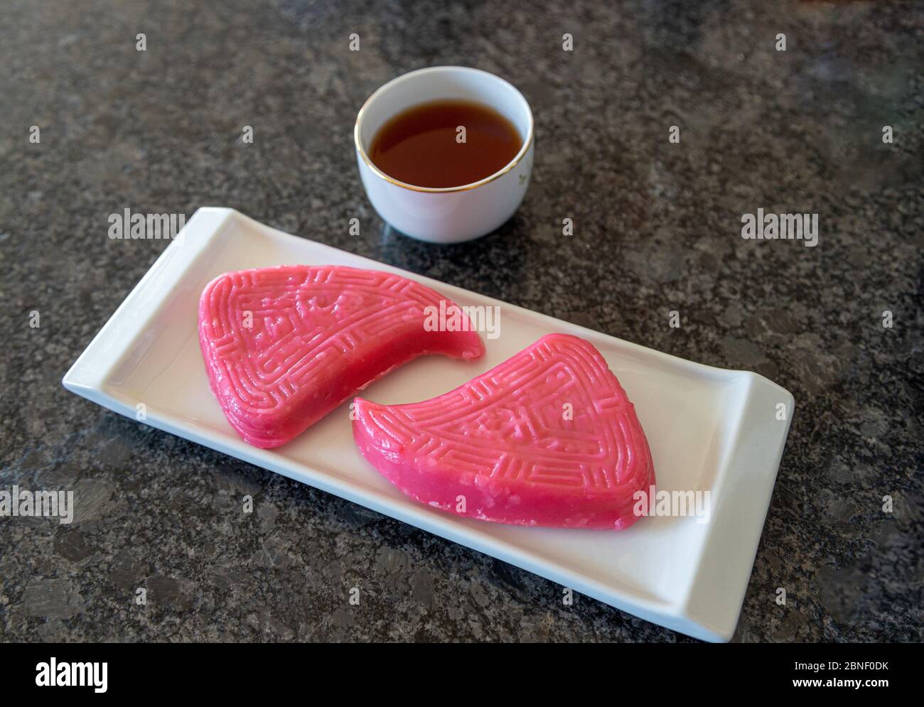 Cucina cinese tradizionale cibo fatto di torta di farina di riso al vapore farcita con riso glutinoso, arachidi e funghi conosciuto come Red Peach Kueh origine Foto Stock