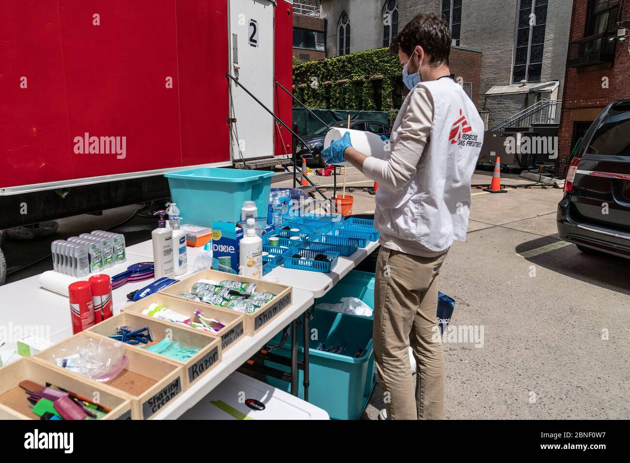 New York, Stati Uniti. 14 maggio 2020. Il membro del personale Tommy Heller prepara articoli da toeletta al trailer di Medici senza frontiere/Medici senza frontiere Sans Frontières per i senzatetto a prendere la doccia calda e radersi nel parcheggio della chiesa di San Giovanni Battista RC durante la pandemia COVID-19. Questo rimorchio mobile per doccia aiuta a pulire fino a 50 persone al giorno. L'organizzazione prevede di impostare un altro trailer nei prossimi giorni per poter servire più persone. Credit: Pacific Press Agency/Alamy Live News Foto Stock