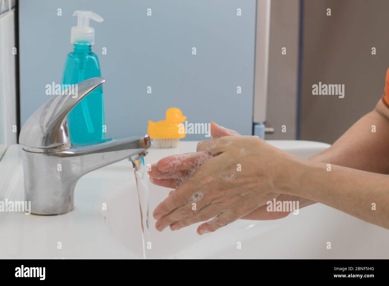 Prevenzione delle pandemie di coronavirus. Lavare le mani con acqua calda e sapone per rimuovere COVID-19, sfregare le unghie e le dita o utilizzare un disinfettante per le mani Foto Stock