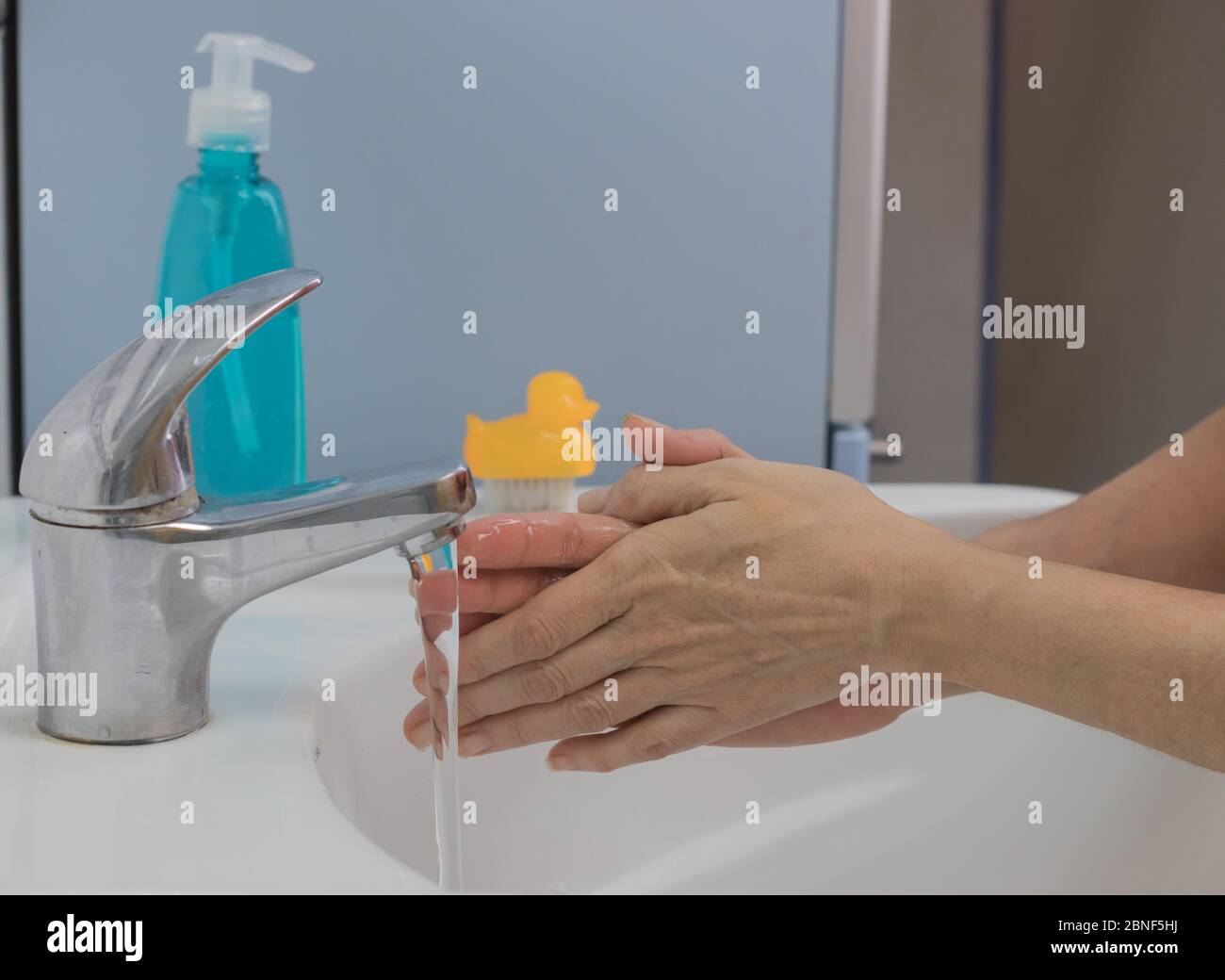 Prevenzione delle pandemie di coronavirus. Lavare le mani con acqua calda e sapone per rimuovere COVID-19, sfregare le unghie e le dita o utilizzare un disinfettante per le mani Foto Stock
