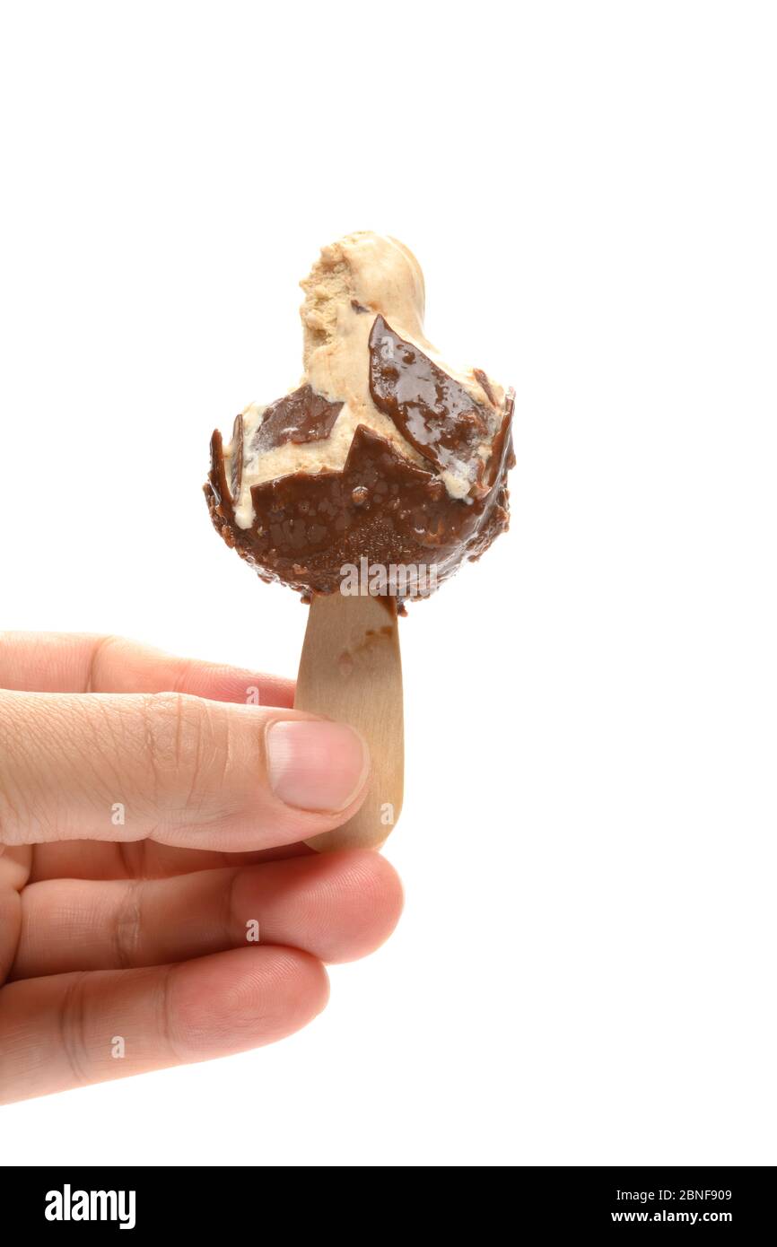 mano che tiene una popsicle di gusto di cioccolato e caffè più mangiato su sfondo bianco Foto Stock