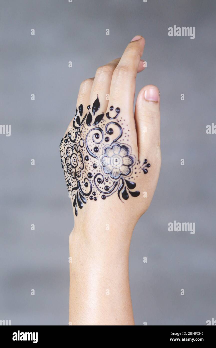 Mano floreale nera Mehndi in mano di ragazze indiane. Foto Stock