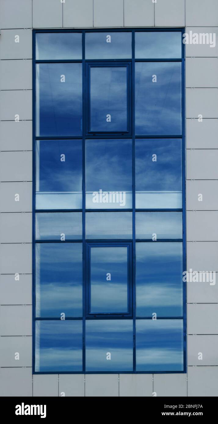 grande finestra opaca con riflesso di un cielo blu Foto Stock